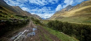 Dirt road surrounded by Andes mountains under a cloudy sky