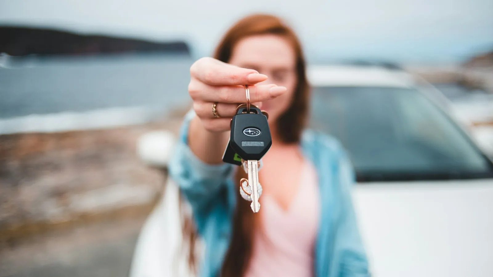 Traveler holding up the keys of a rental car