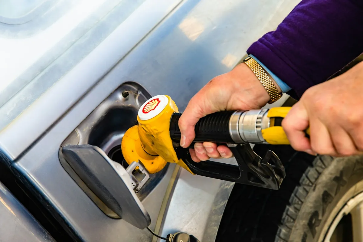 Refueling a car at the pump before returning a rental