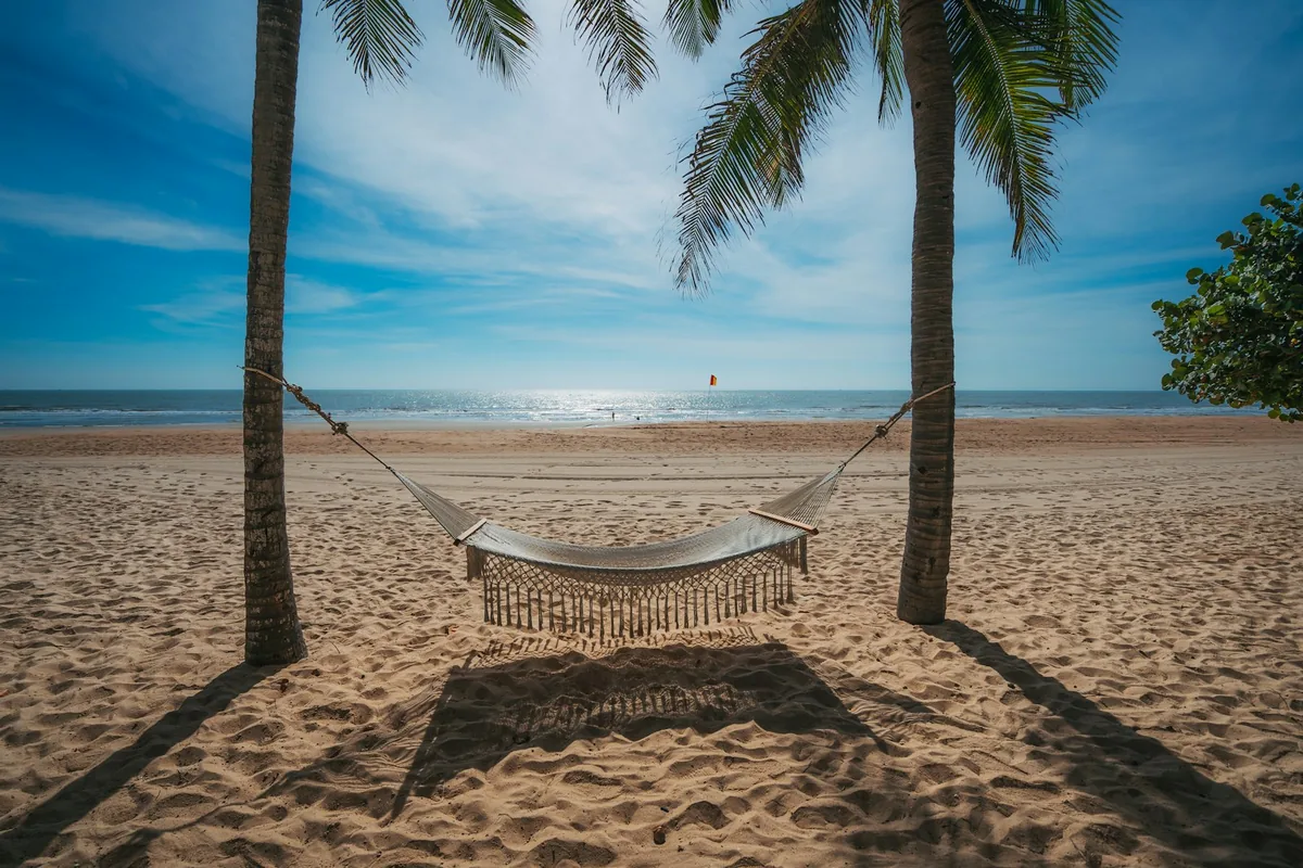 Hammock hanging between palm trees on a tropical beach