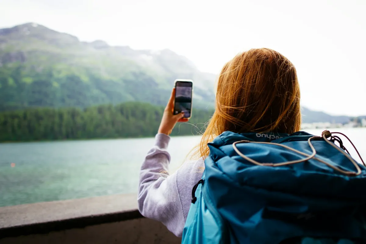 Reisender in den Bergen, der ein Smartphone hochhält