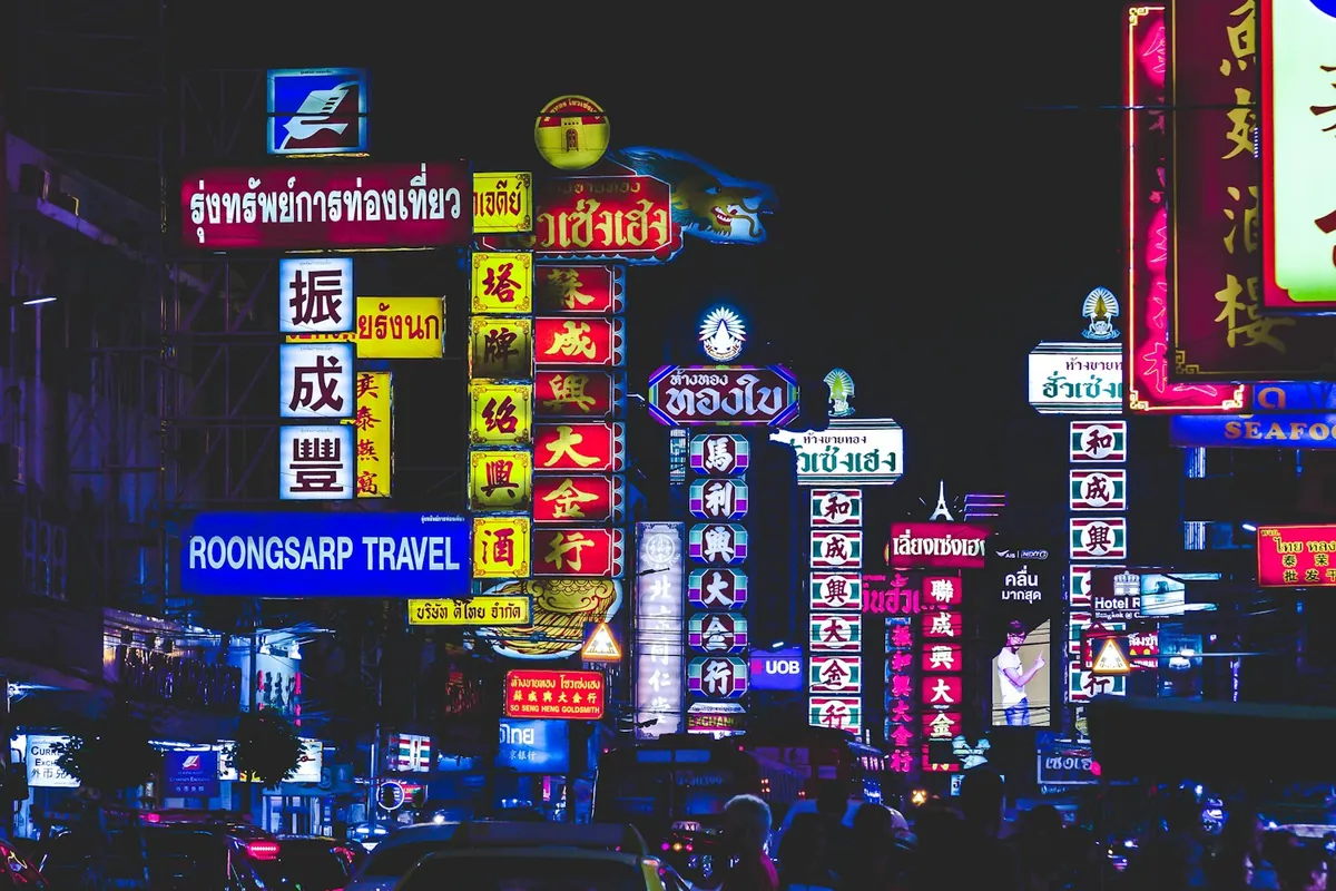 Neon signs lighting up a street in Bangkok at night