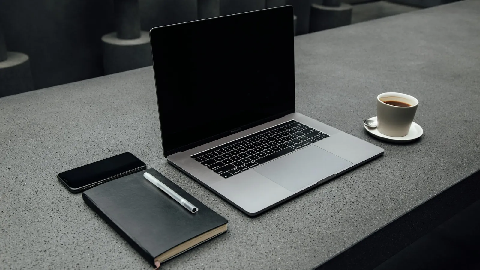 Laptop, notebook, phone and coffee cup on a clean desk ready for a productive workday