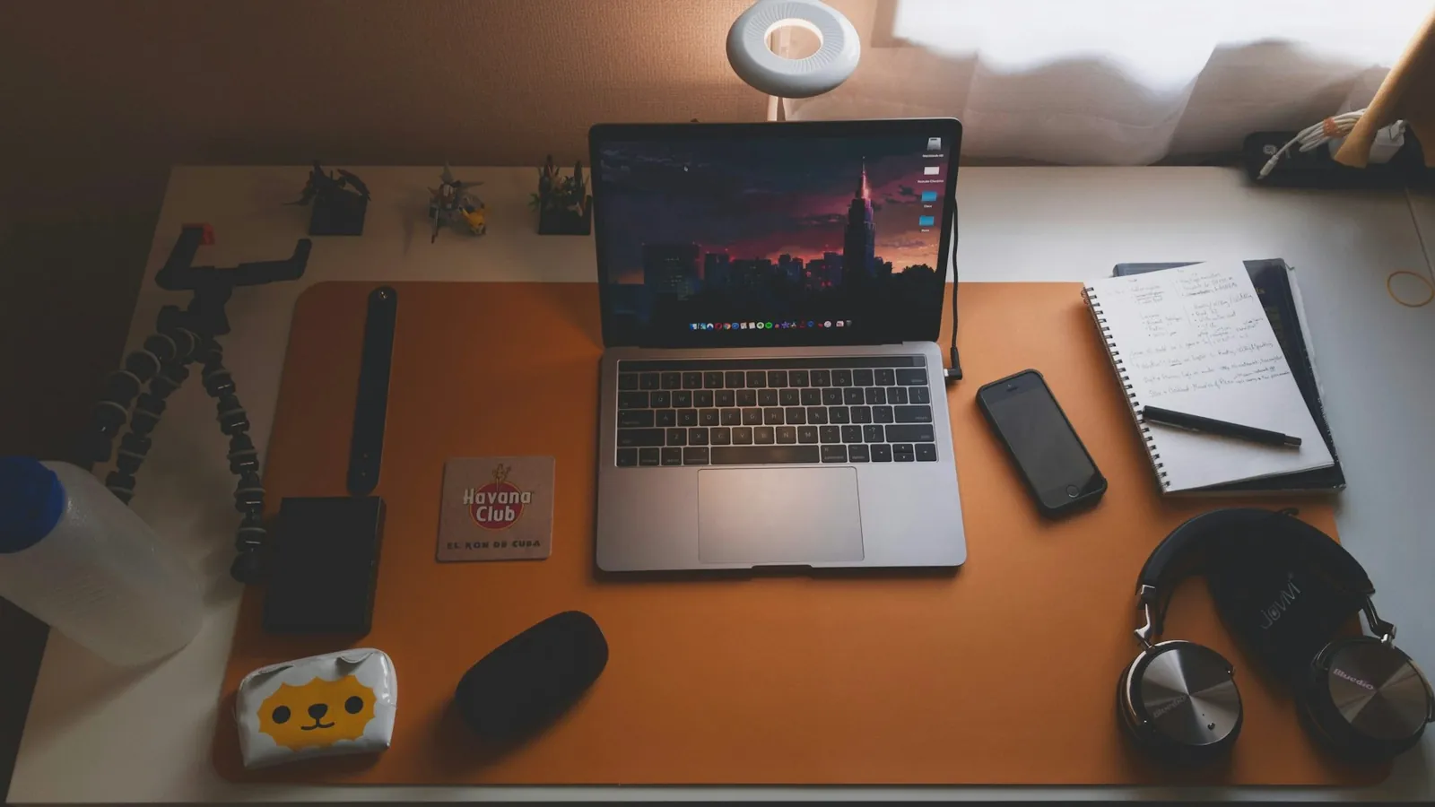 Laptop, headphones, phone and notebook on a desk, a compact remote work setup