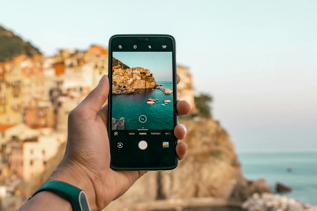 Phone taking a photo of a colorful coastal village