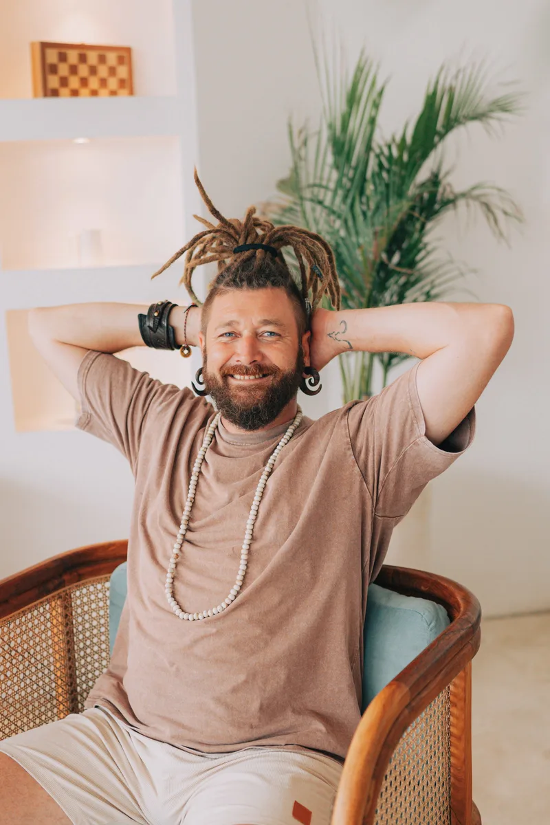 Chenzo, holistic coach and founder of NomadsToolsLab, sitting relaxed in a chair