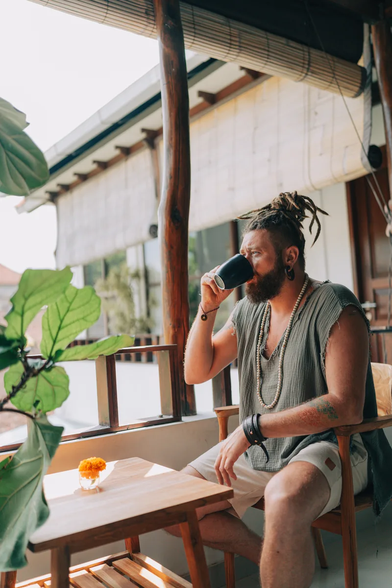 Chenzo, Gründer von NomadsToolsLab, beim Kaffeetrinken auf einer Veranda in Asien