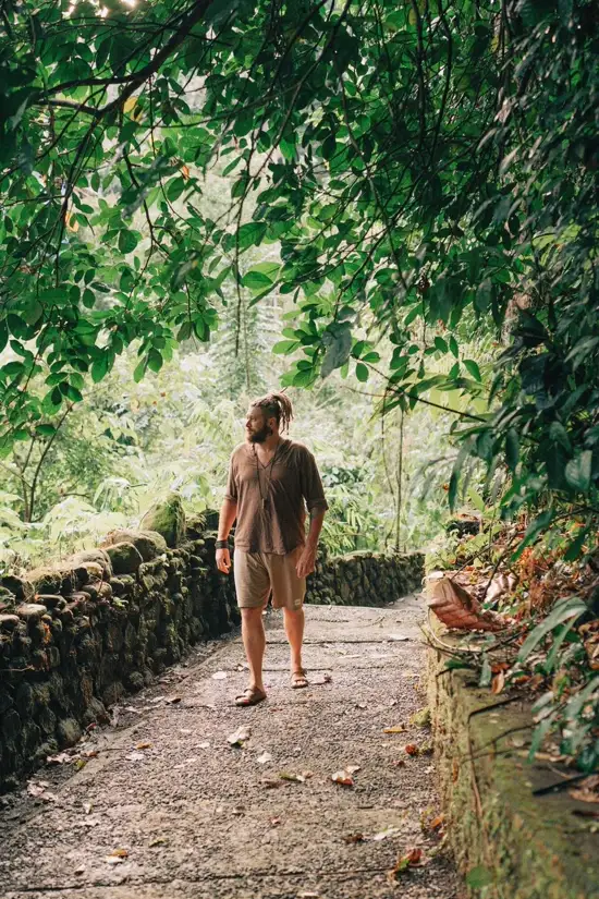 Chenzo, founder of NomadsToolsLab, walking down a jungle stone path in Bali