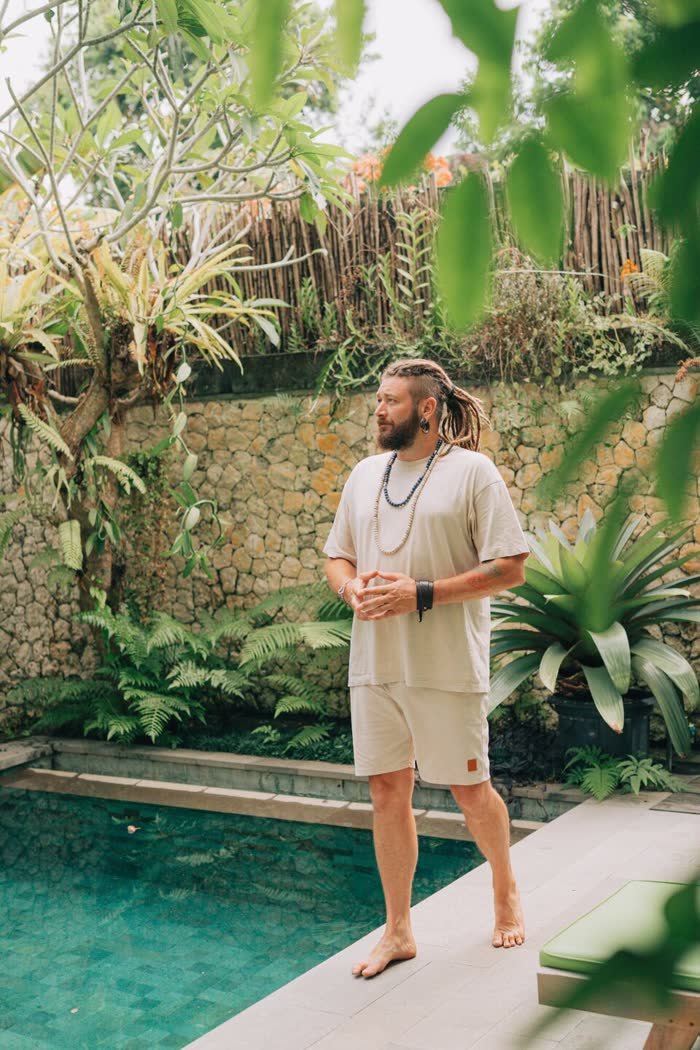 Chenzo, founder of NomadsToolsLab, standing by a pool surrounded by tropical plants in Bali