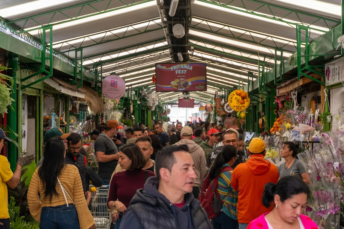 Crowded indoor market street with many shoppers close together