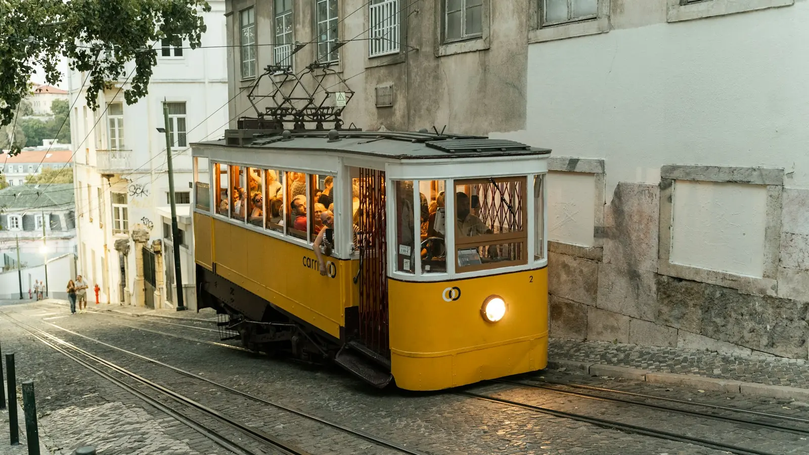 Yellow tram on a cobbled street in Lisbon, Portugal