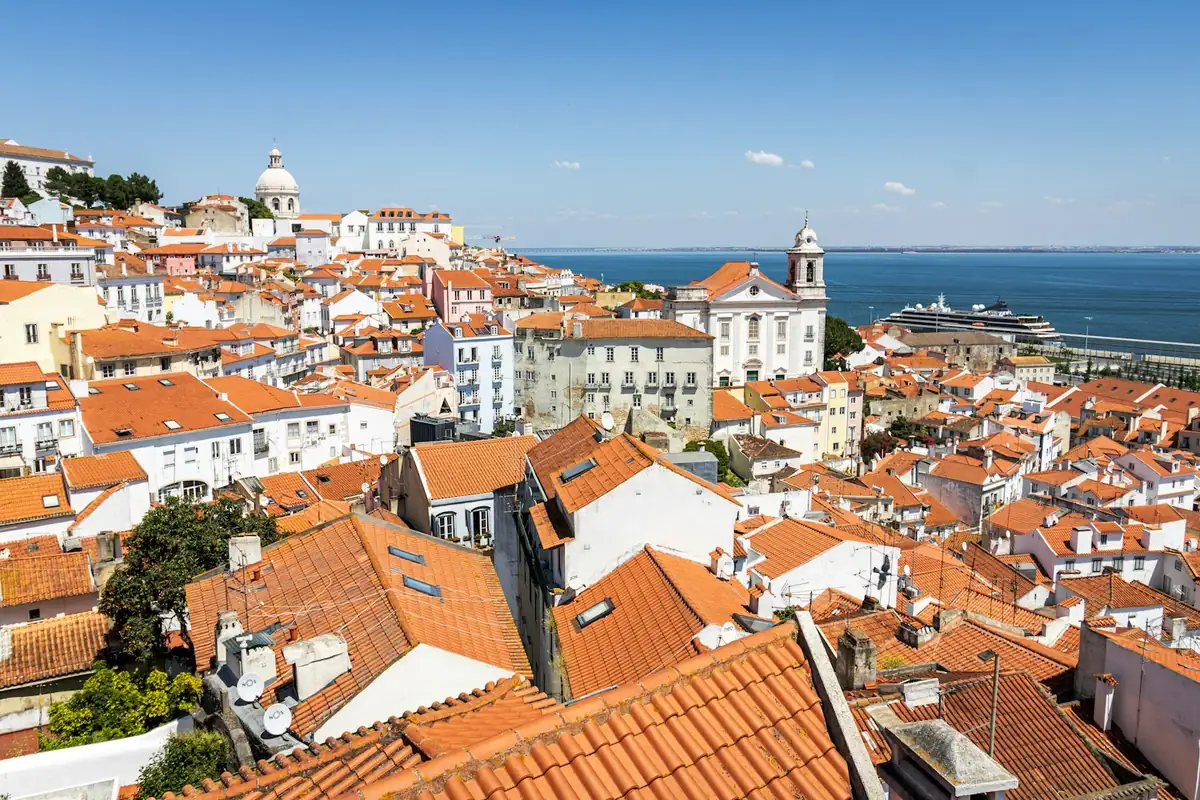 Terracotta rooftops of Alfama with the river behind, Lisbon