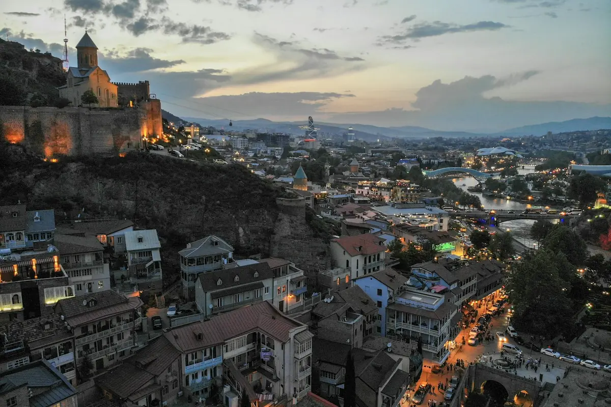 Tbilisi old town and hilltop fortress lit up at dusk