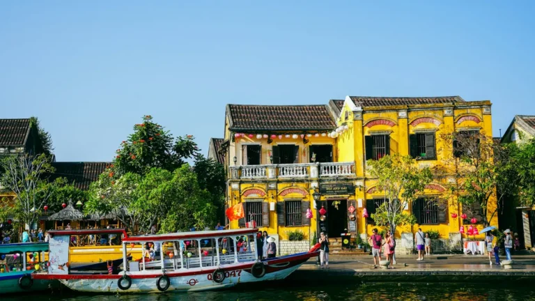 Yellow colonial houses and boats along the river in Hoi An, Vietnam