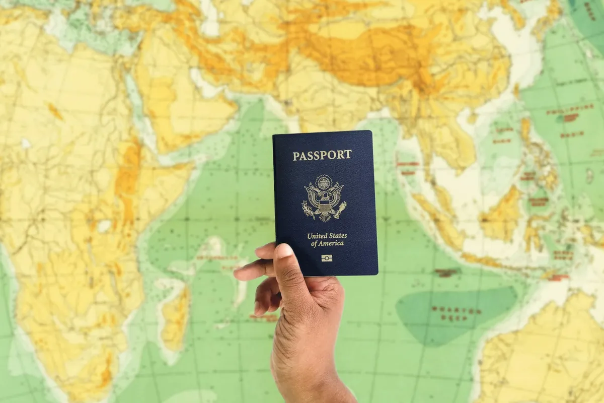 Passport held over a world map while planning a move abroad