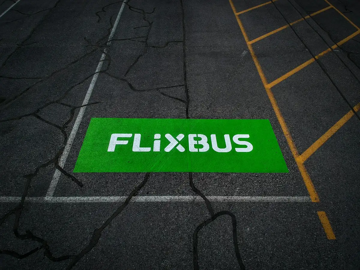 Un logo verde de FlixBus pintado en el suelo de una parada de autobús