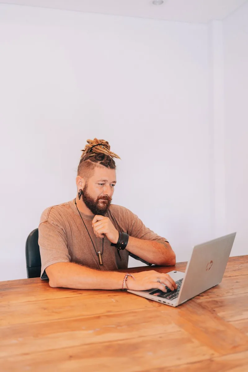 Chenzo working on a laptop at a wooden table
