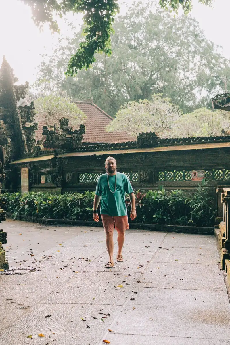 Chenzo walking near a traditional Balinese temple wall