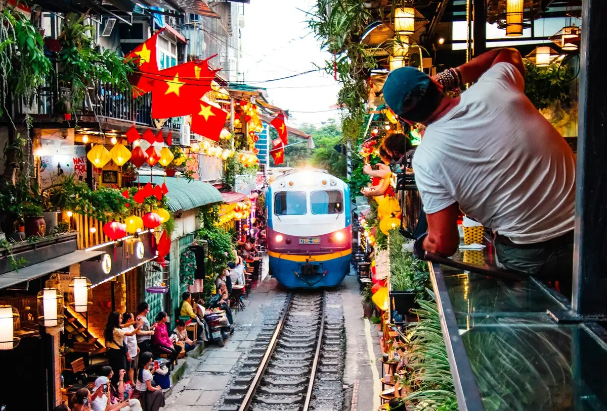 A train passing through the narrow lanes of Hanoi Train Street in Vietnam