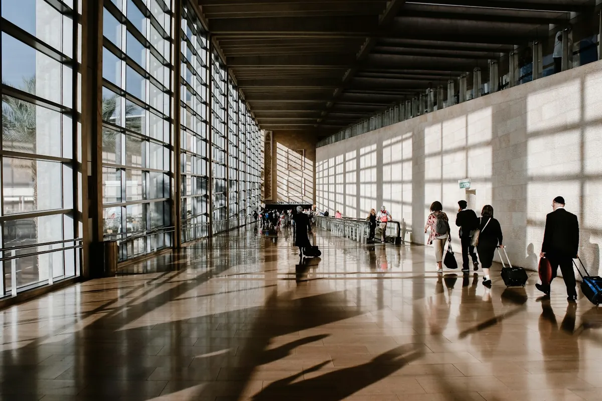 Travelers with luggage walking through an airport terminal