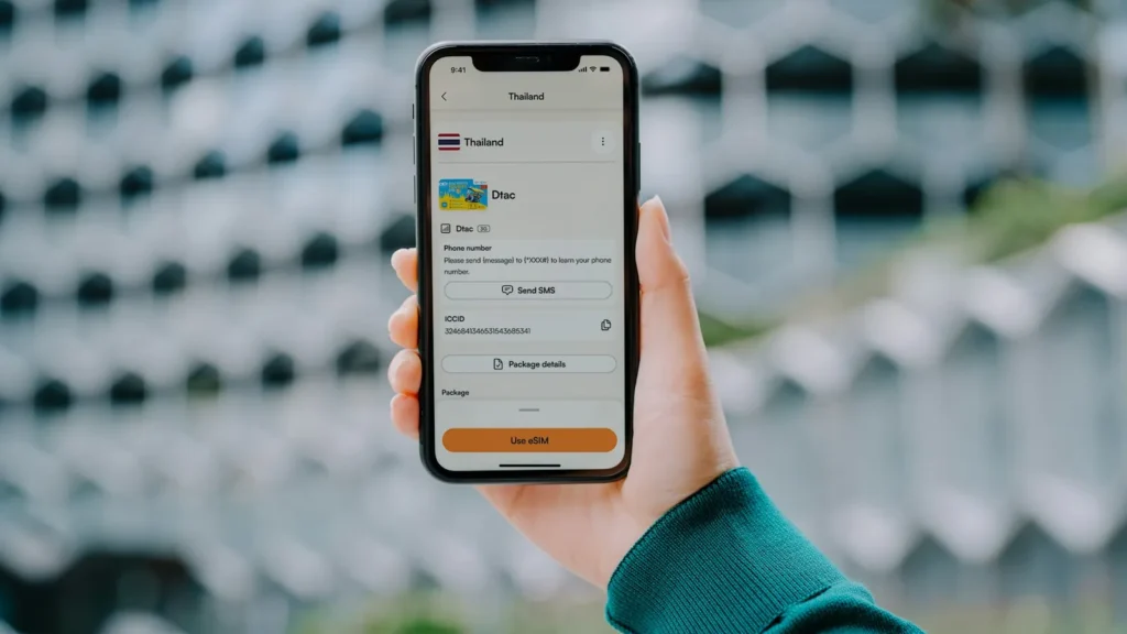 Hand holding a smartphone with an eSIM data plan open on screen
