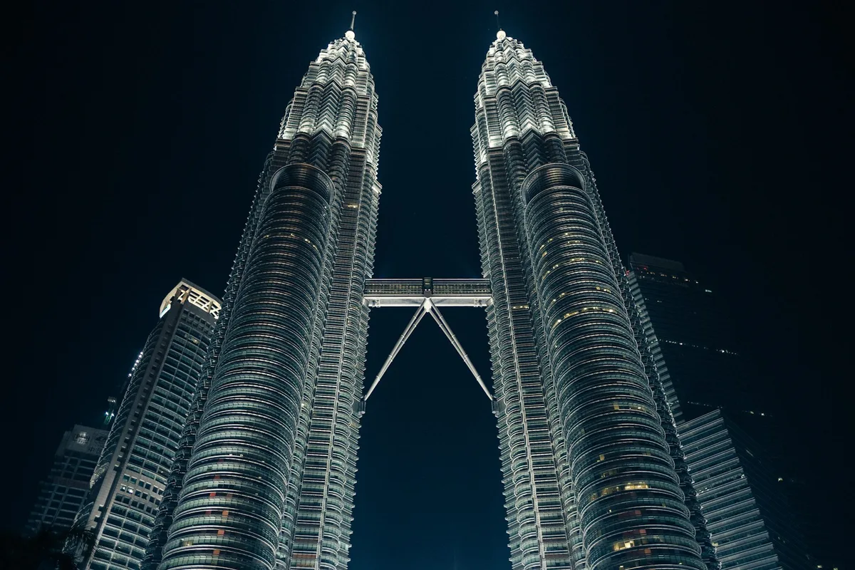 Vista hacia arriba del puente elevado de las Petronas Twin Towers de noche en Kuala Lumpur