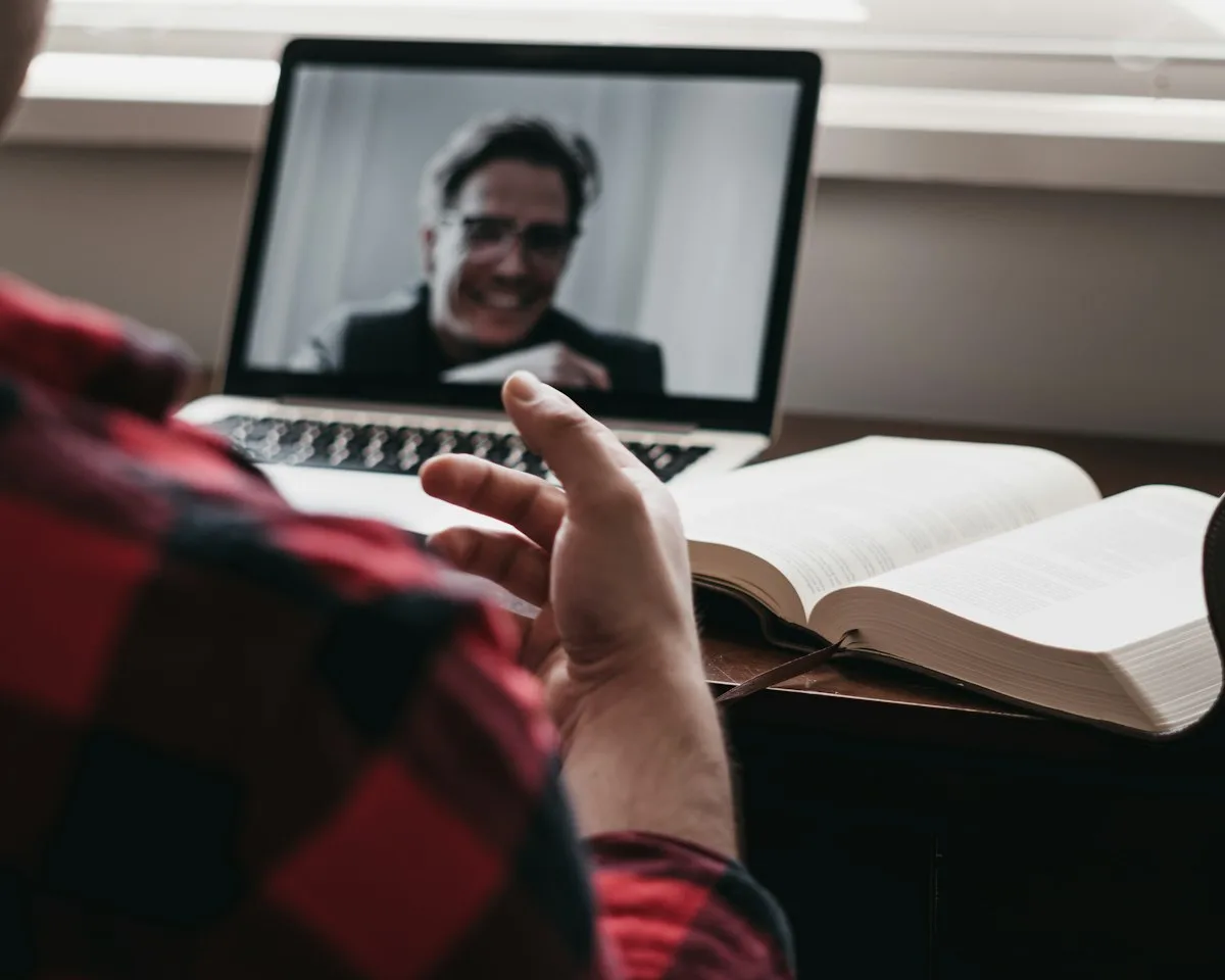 Digital nomad taking an online language lesson with a tutor on a laptop