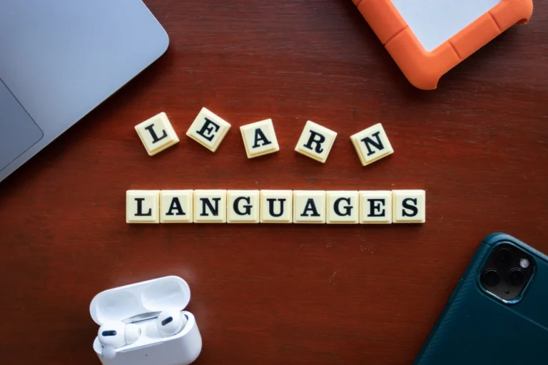 Letter tiles spelling learn languages on a wooden desk