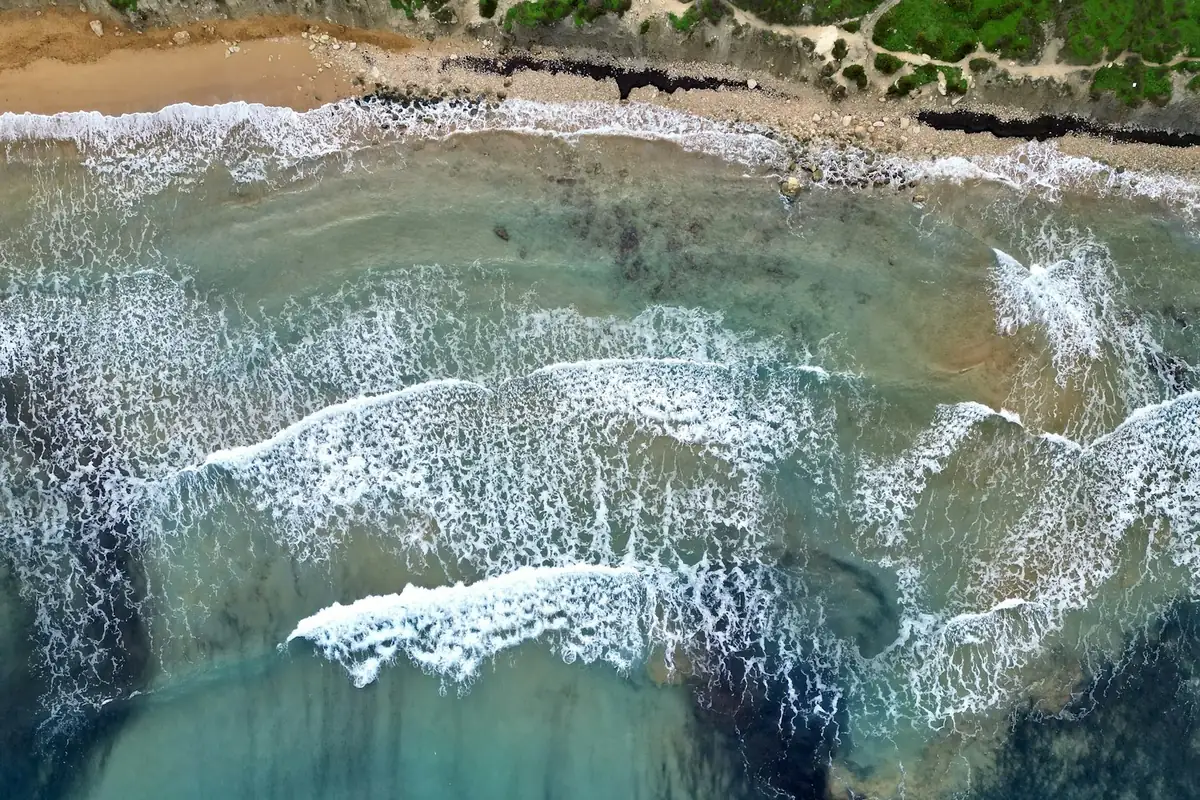 Aerial view of a beach and turquoise ocean at Riviera Beach, Malta