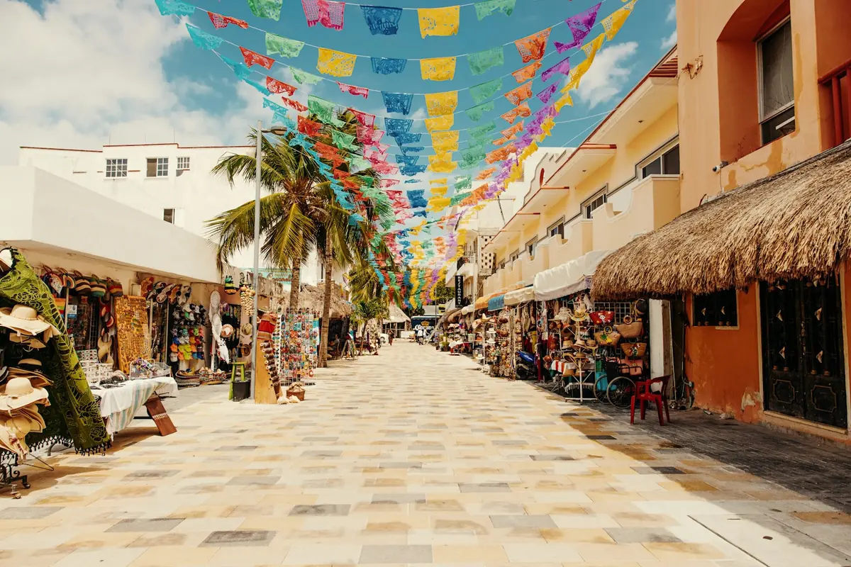 Pedestrian shopping street under paper flags in a Mexican beach town