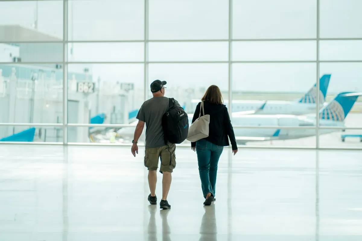 Two travelers walking through a bright airport terminal