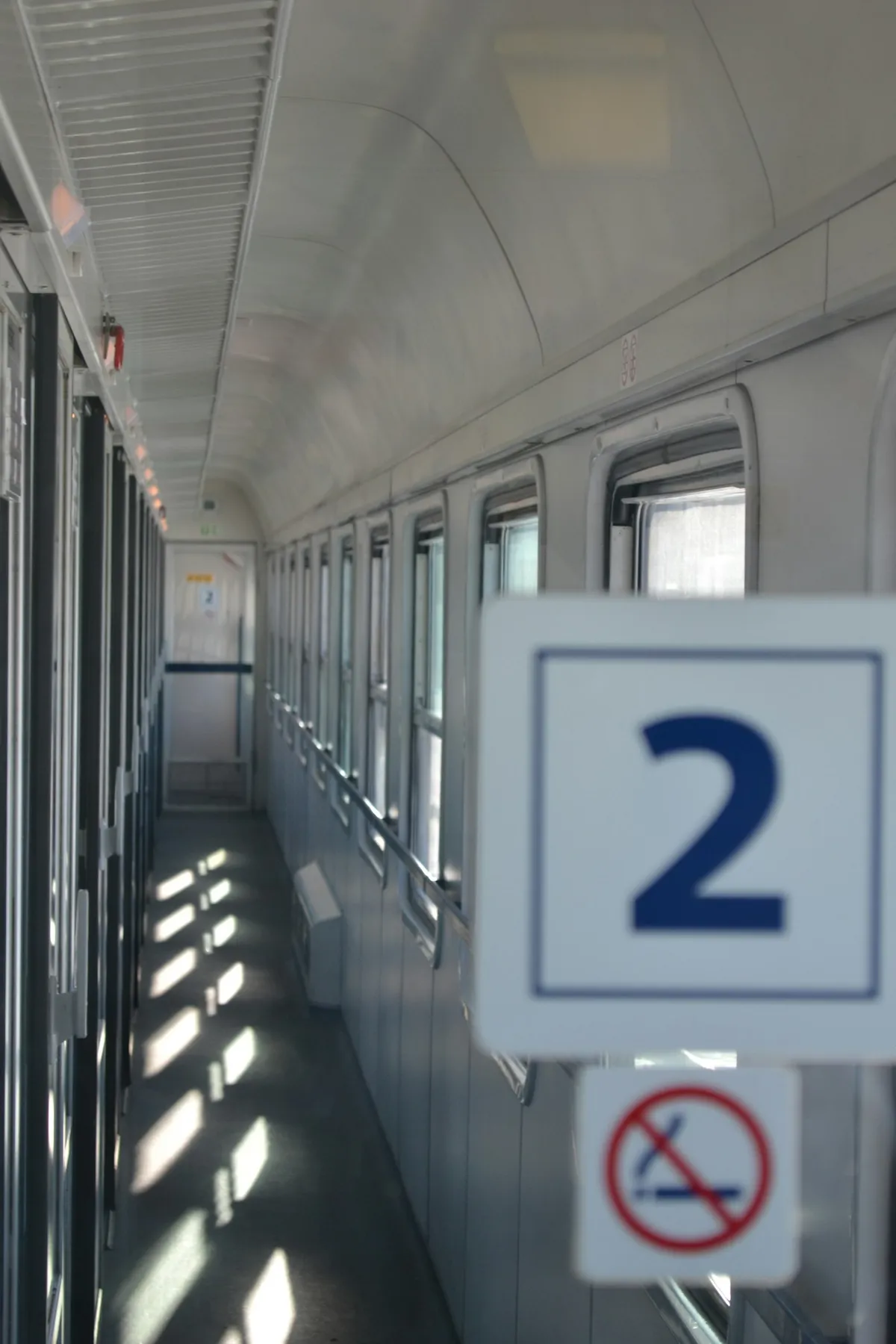 El pasillo de un vagón de segunda clase de un tren nocturno europeo, con ventanas de los compartimentos