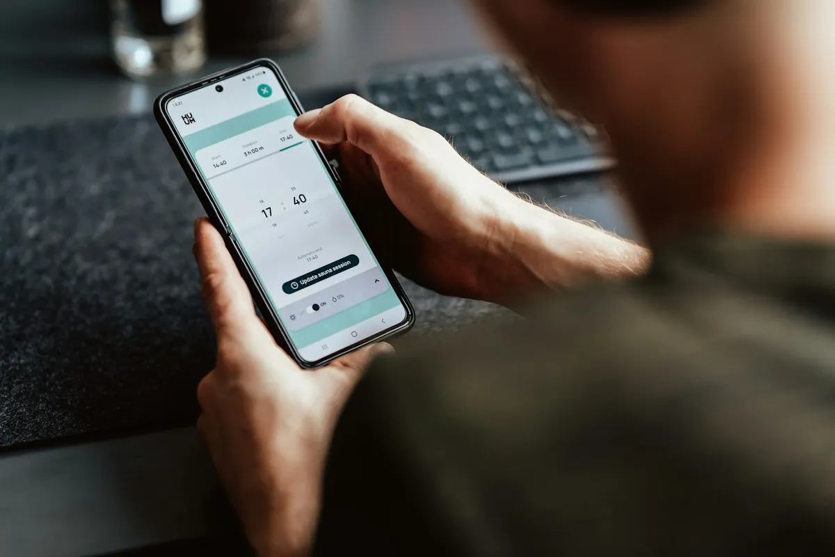 Hands holding a smartphone with an app open