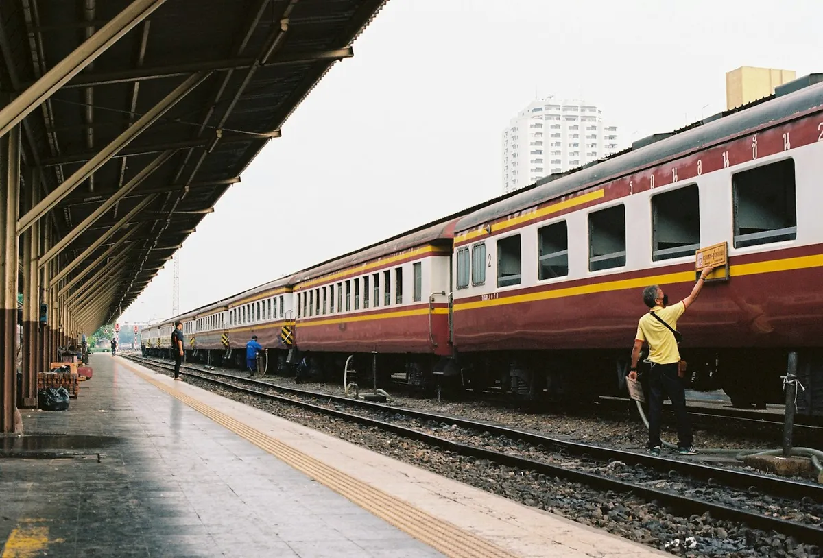 A classic maroon and cream State Railway of Thailand train at a Bangkok platform