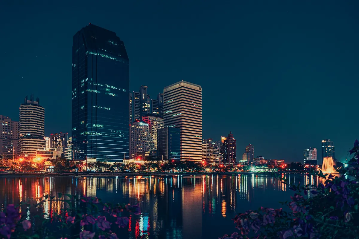 El horizonte de Bangkok iluminado de noche, visto desde el otro lado del agua