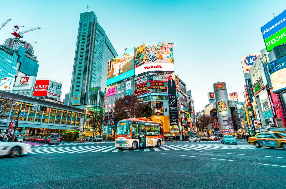 A bus crossing the Shibuya Scramble Crossing in daytime Tokyo