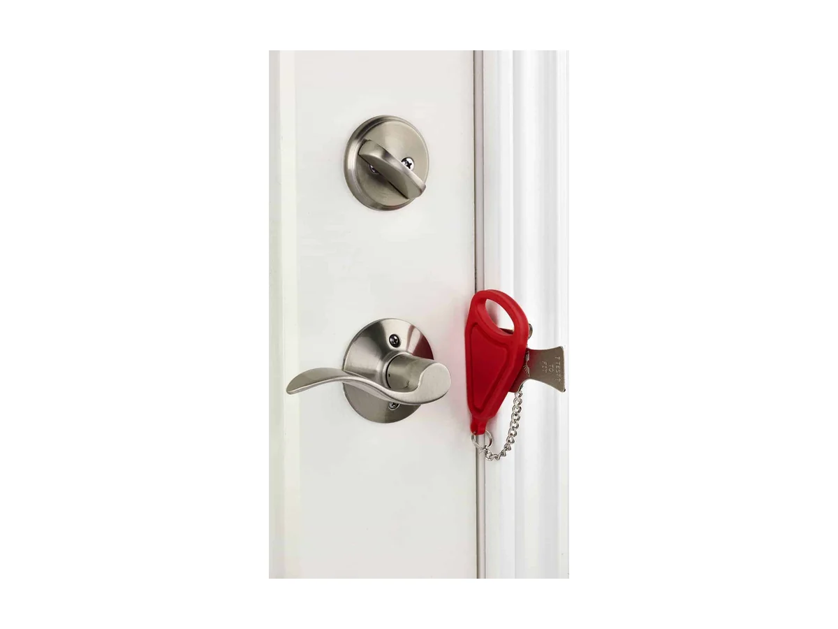 Rode Addalock draagbare deurslot bevestigd bij het slotplaatje van een witte deur met een zilveren deurklink