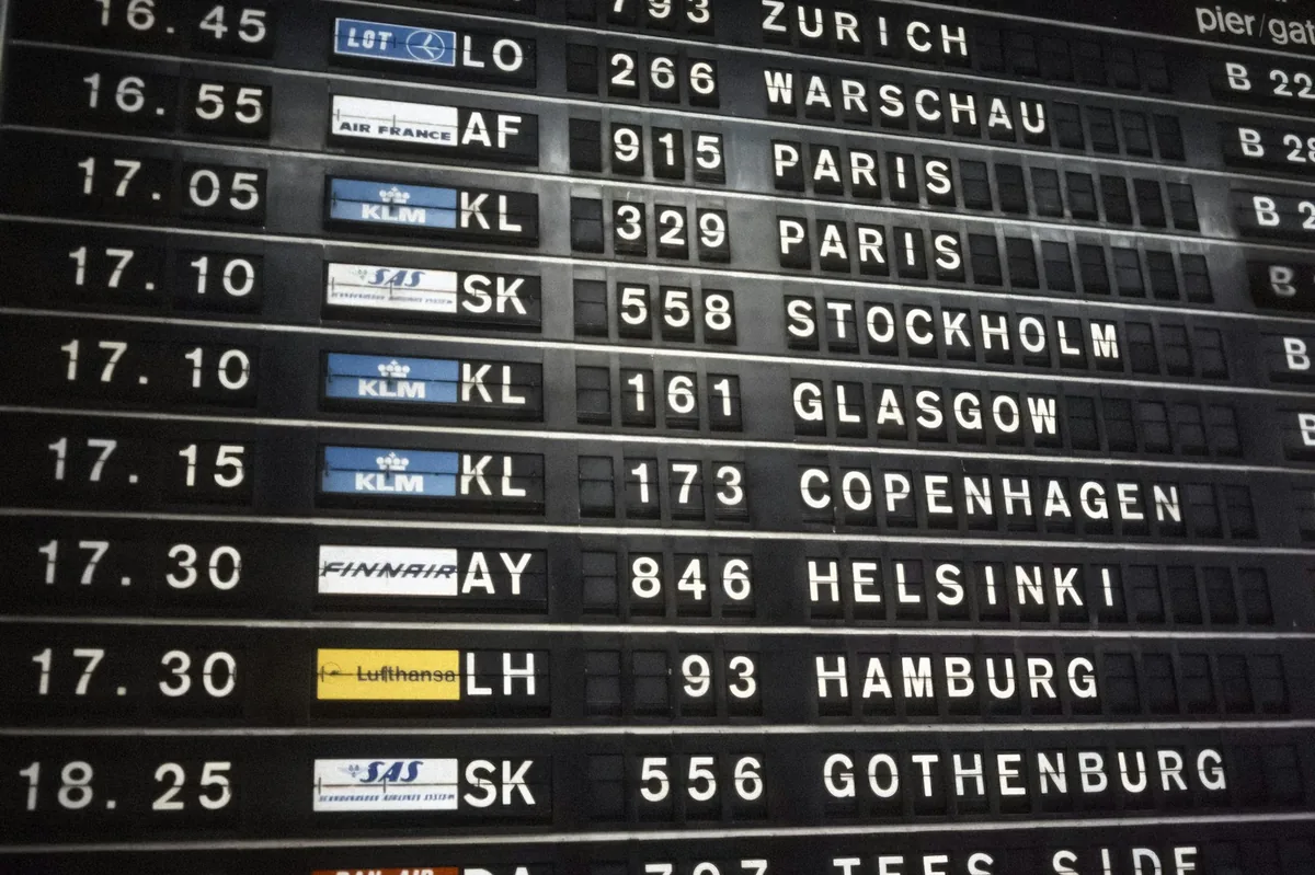 Airport departure board listing flight destinations and times