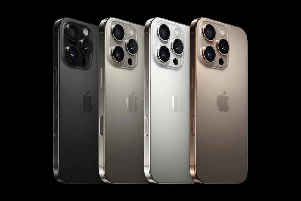 Four Apple iPhone 16 Pro phones in black, white, natural and desert titanium shown from the back