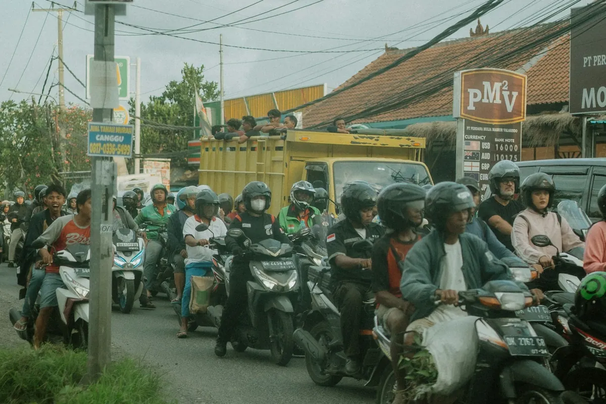 Motos y un camión atascados en tráfico lento en una carretera de Bali
