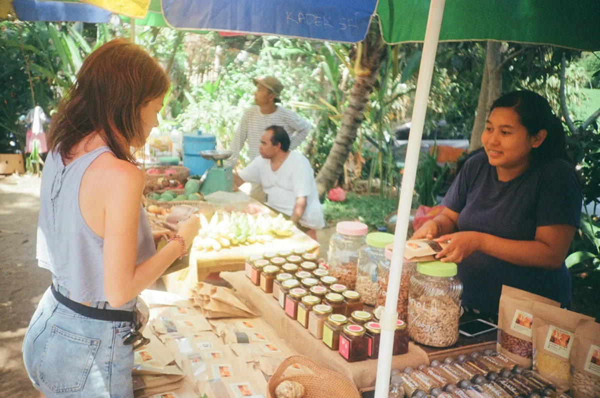 Mujer comprando en un puesto de mercado local en Bali