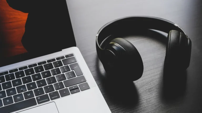 Black noise cancelling headphones next to a laptop, best noise cancelling headphones for remote workers