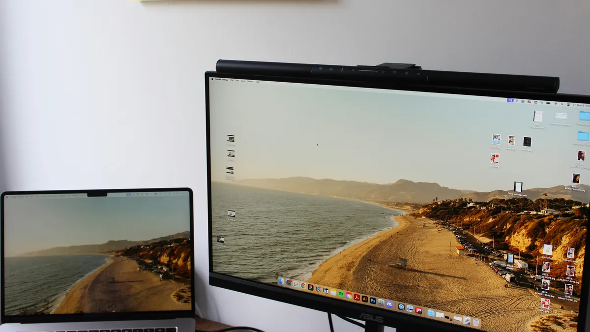 Laptop beside a large monitor on a desk, best portable monitors for digital nomads