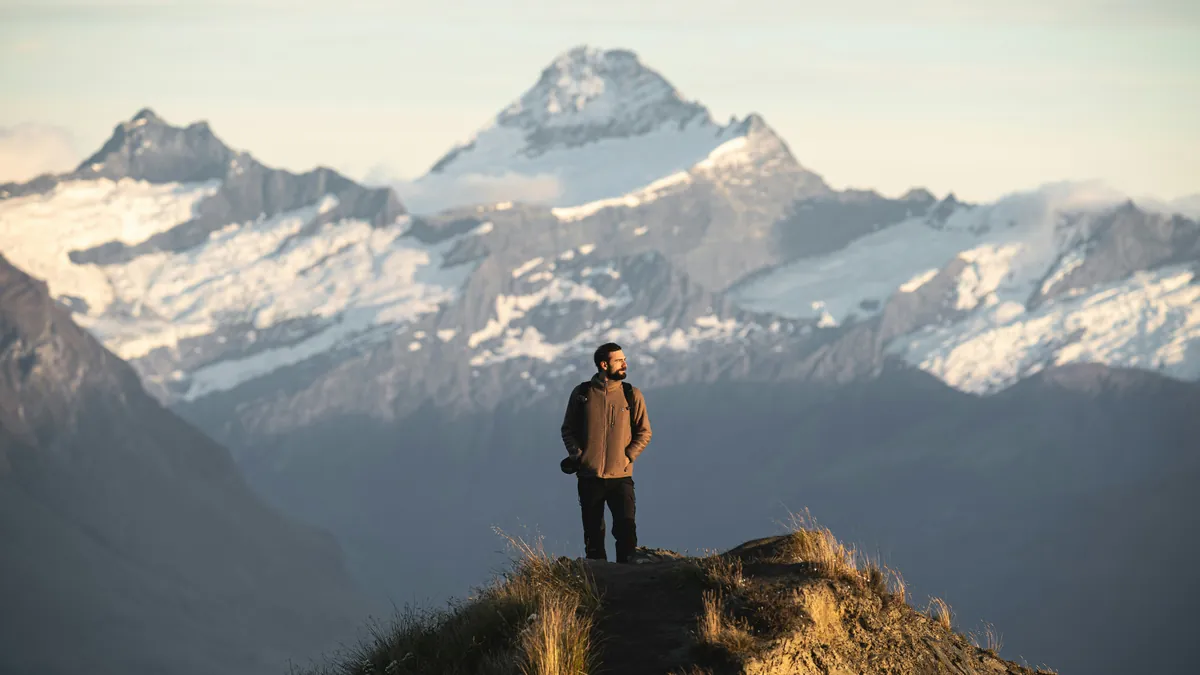 Traveler with a backpack on a mountain ridge, best travel insurance plans for digital nomads