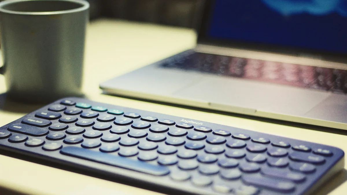 Compact wireless keyboard in front of a laptop on a desk, best travel keyboards for digital nomads