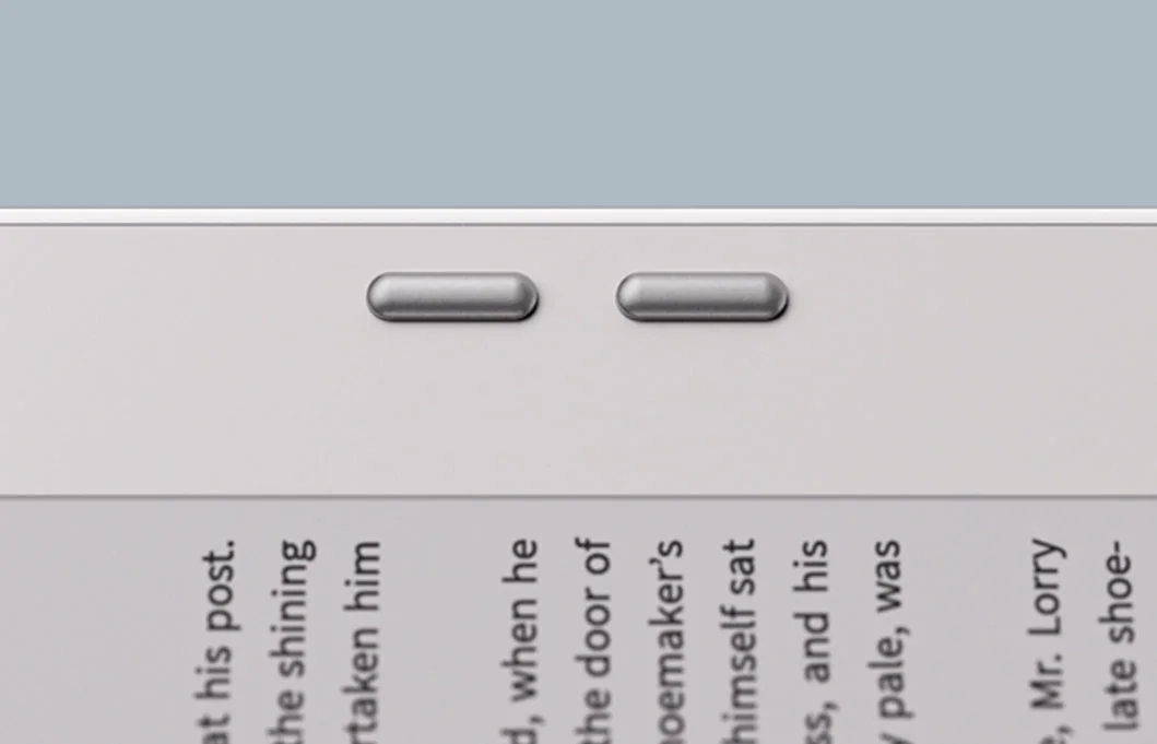 Close-up of the two physical page-turn buttons on the edge of a BOOX Go Color 7 beside a page of text