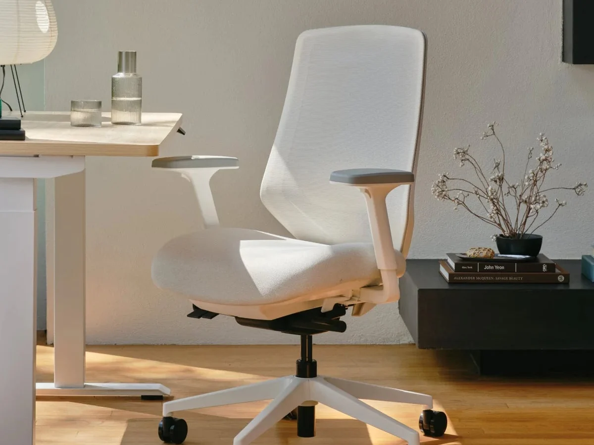 White Branch Ergonomic Chair Pro with mesh back and adjustable arms at a light wood desk