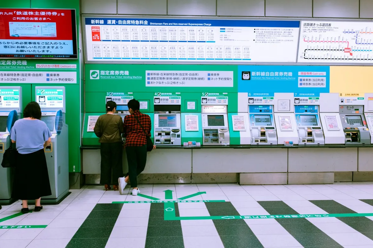 Personas comprando billetes de tren en una estación