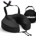 Black Cabeau Evolution S3 neck pillow with its seat straps looped up and the round black carry case behind it