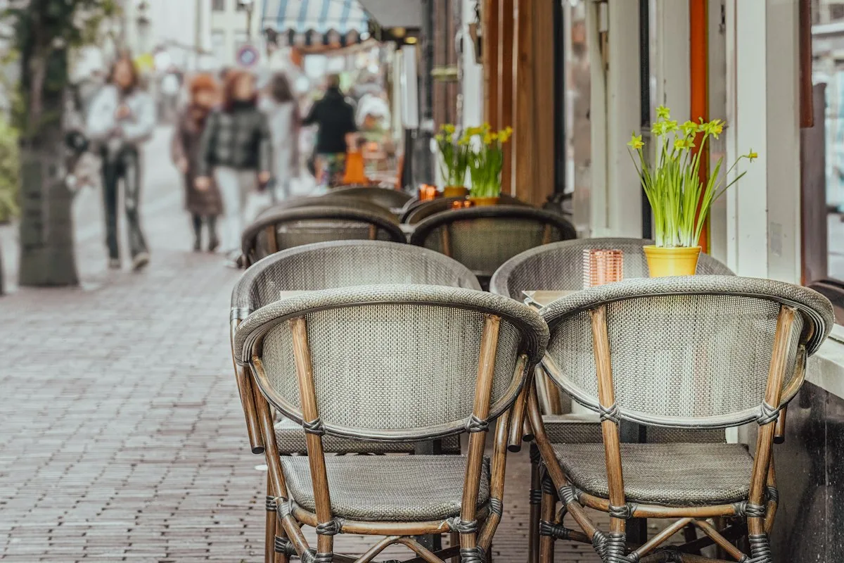Korbstühle und Tische eines Cafés auf einer Fußgängerstraße